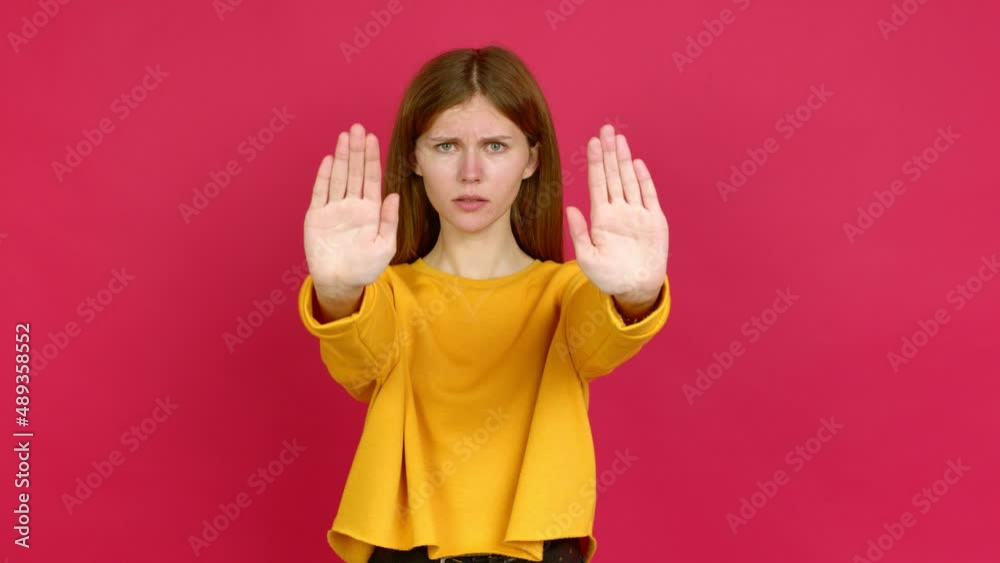 Young woman doing stop sign over isolated background Young woman doing stop sign over isolated background