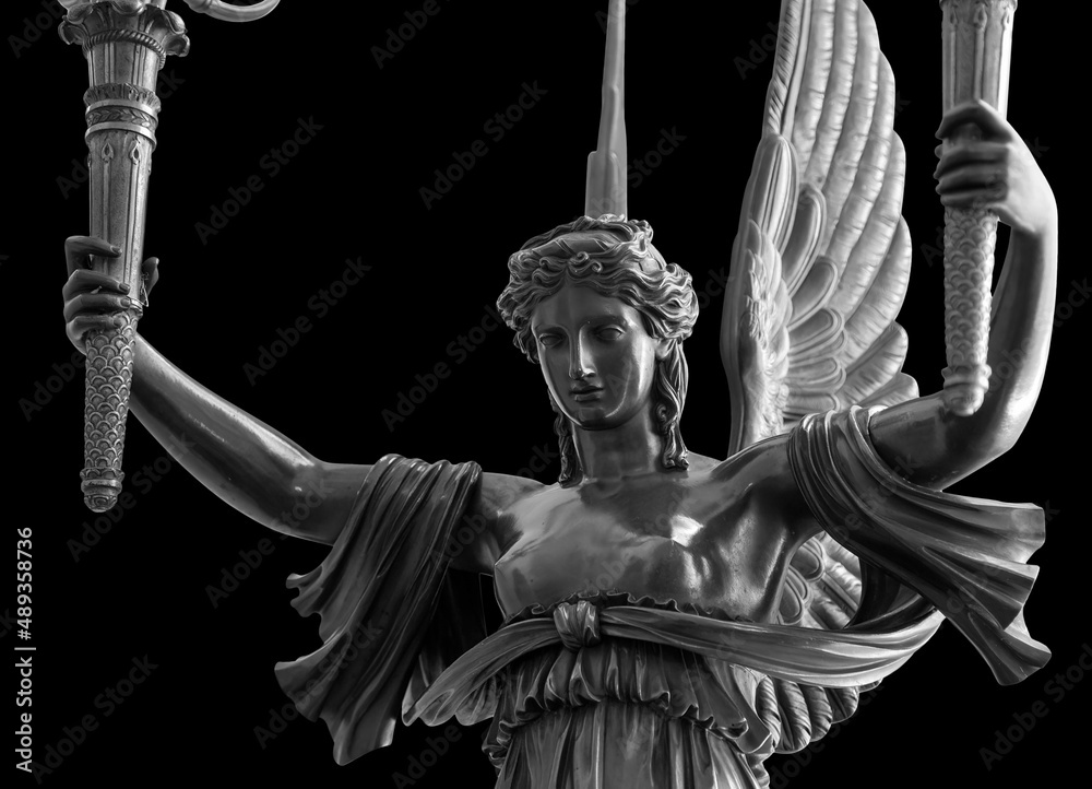 Sculpture of a Winged Victory goddess Nika. Statue of a beautiful holy  angel with wings holding a torchs isolated at black background with  clipping path Stock Photo | Adobe Stock