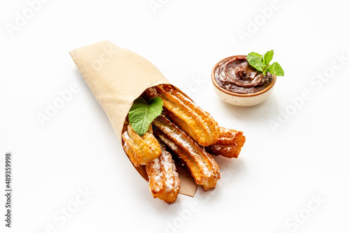 Street food dessert churros in paper bag with sugar