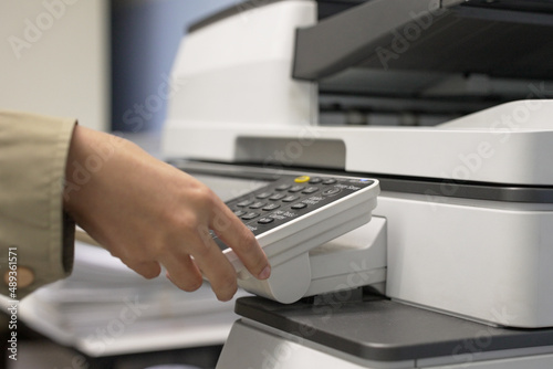 Hand of woman is using a photocopier to copy documents.