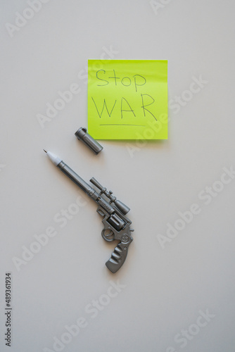 a pen in the form of a pistol lies on a table on a white background. Near the sticker 