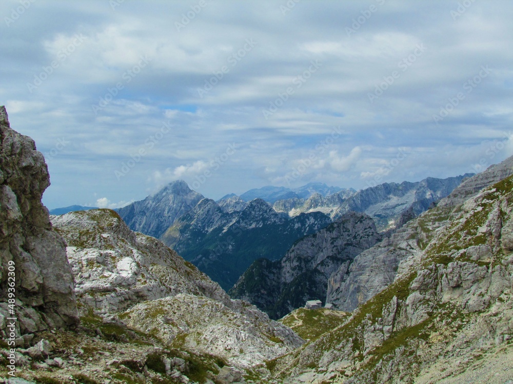 High alpine rocky landscape at Kriski podi in Triglav national park and Julian alps in Slovenia and the mountain hut Pogacnikov dom na Kriskih podih and Kanin mountains in the background