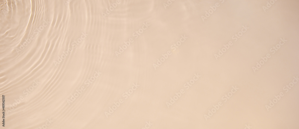 Abstract summer banner background Transparent beige clear water surface texture with ripples and splashes. Water waves in sunlight with copy space Cosmetics moisturizer micellar toner emulsion Abstract summer banner background Transparent beige clear water surface texture with ripples and splashes. Water waves in sunlight with copy space Cosmetics moisturizer micellar toner emulsion