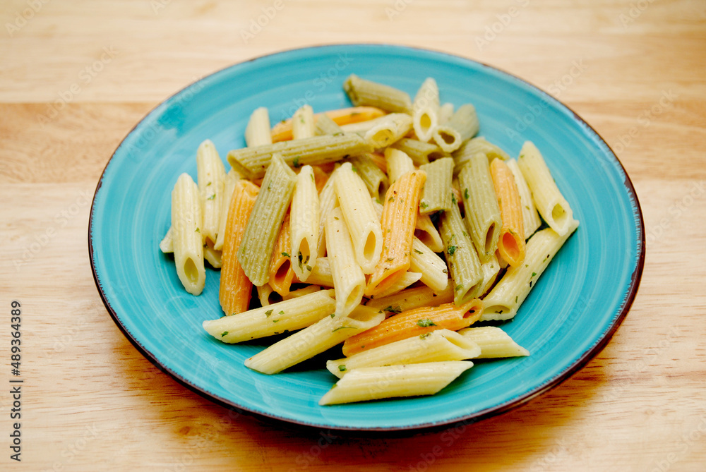 Plate of Cooked Cylinder-shaped Penne Pasta Noodles in Three Colors Yellow, Green and red