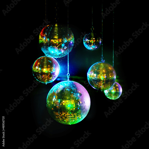 Mirror balls above dance floors. Awesome image of kaleidoscopic-looking disco balls hanging against a black background. photo