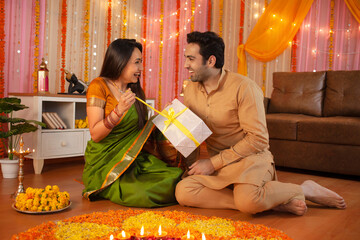 Young Indian couple - Happy husband gifting his wife on Diwali festival