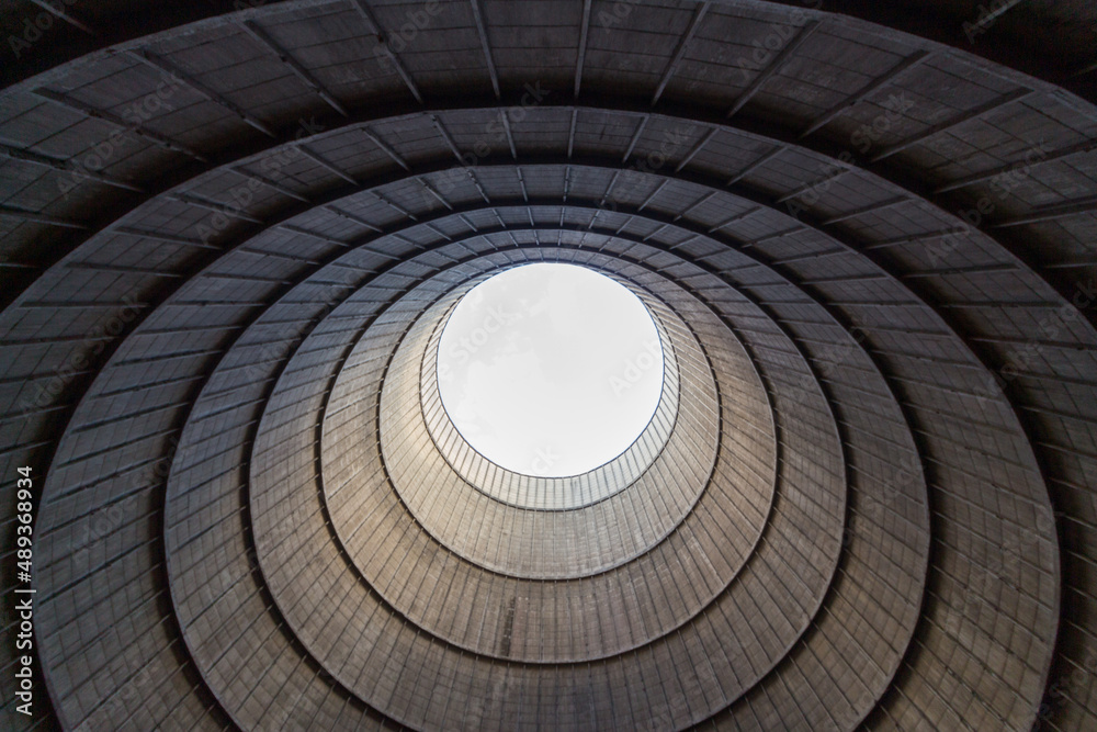 Inside a cooling tower of a nuclear power plant. View upwards, sky with haze