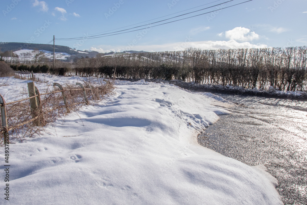 Snow covered land and fence.