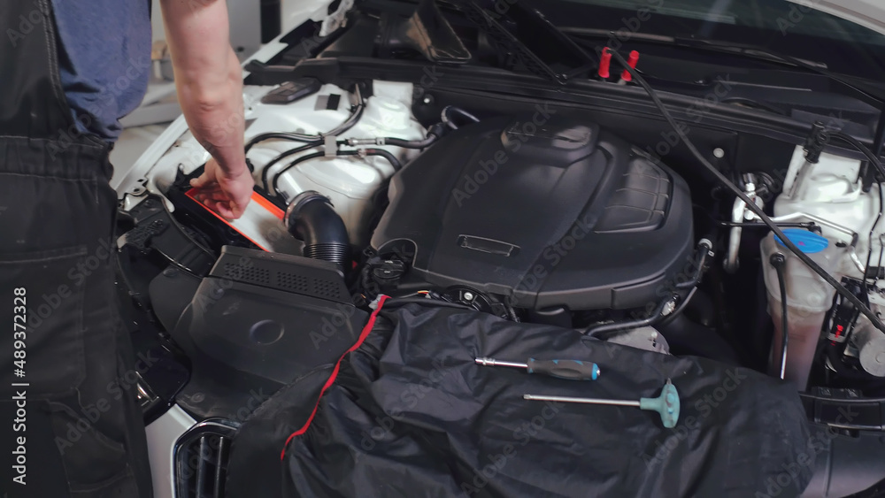 Cropped shot of mechanic reparing broken car Cropped shot of mechanic reparing broken car