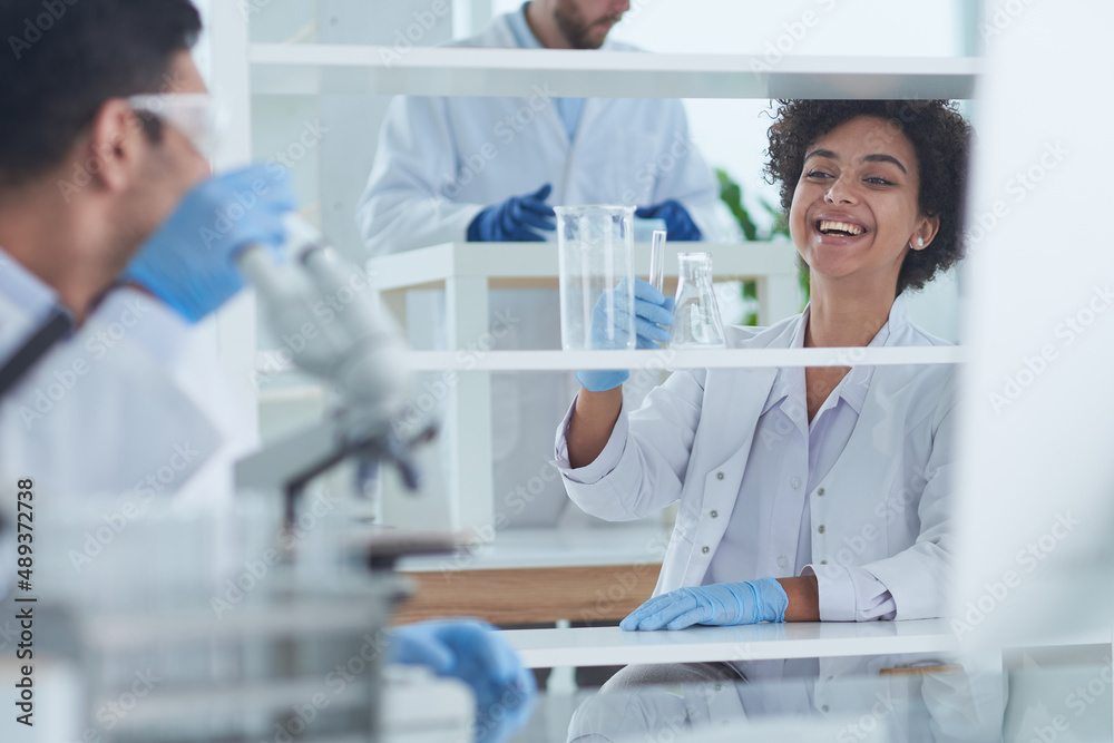 Smiling scientists looking at camera arms crossed in laboratory Smiling scientists looking at camera arms crossed in laboratory