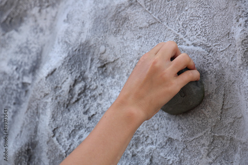 A close-up of the hand of a child climbing a mobile climbing wall
