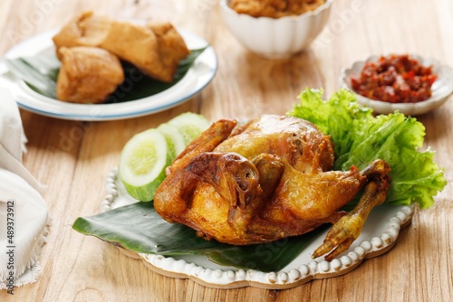 Deep Fried Whole Fried Chicken, Served with Cucumber, vegetable, and Sambal.