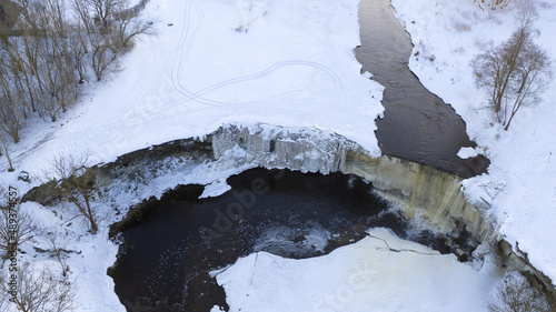 Aerial view to the winter ice clad waterfall on limestone cliff photo