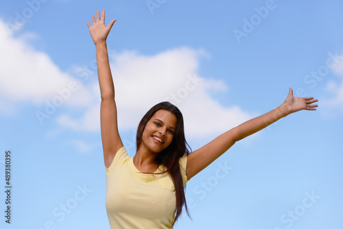 This is freedom. Shot of a woman enjoying the outdoors with her arms raised to the sky.