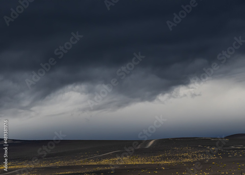 Black lava fields near Tolbachik volcano in Kamchatka peninsula, Russia. Summer landscape with stormy sky.