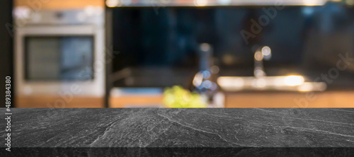 black marble stone counter top with blurred kitchen interior background photo