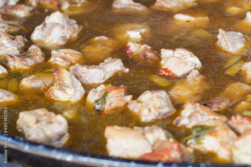 Preparation of a tasty rice with ribs with broth and pieces of pork over a wood fire Preparation of a tasty rice with ribs with broth and pieces of pork over a wood fire