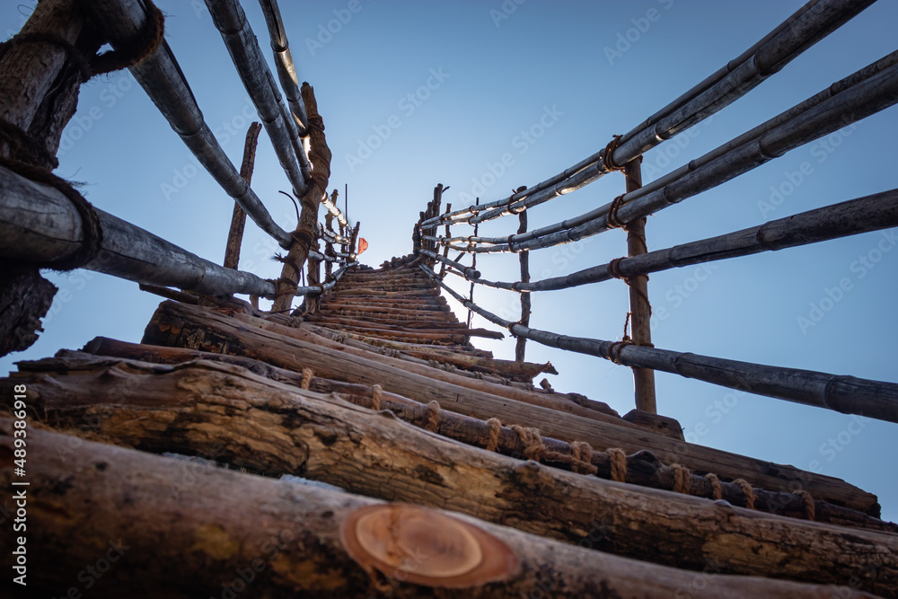 traditional bamboo stairs leading to the bright blue sky from low angle traditional bamboo stairs leading to the bright blue sky from low angle