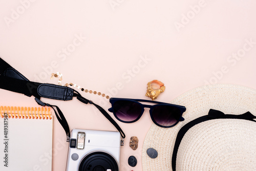 summer travel accessories. camera, hat, glasses and top view on a light background. with space for your text