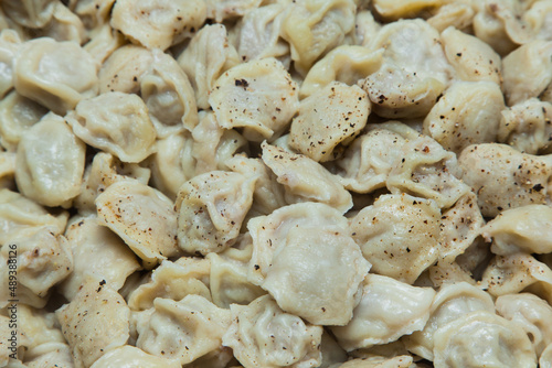 Boiled dumplings sprinkled with spices on top. Background of Dumplings.