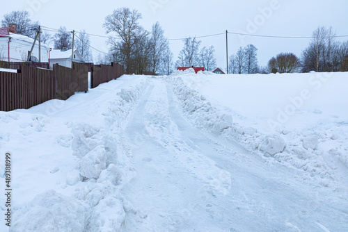 Beautiful, bright, colorful and vivid background of rural snow road in village or little town among low houses