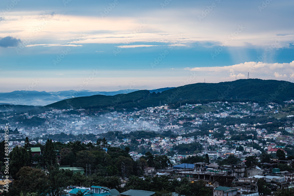 Obraz premium downtown city view with dramatic cloudy sky at evening from mountain top