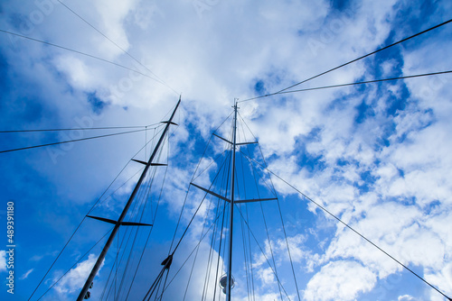 Mast of sailing yachts with ropes for fastening, closeup.