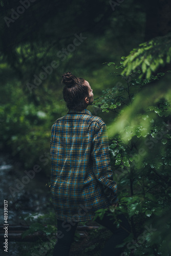 Girl wearing a flannel shirt in the woods