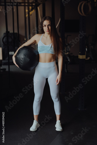 Sport woman portrait with weight ball in a gym