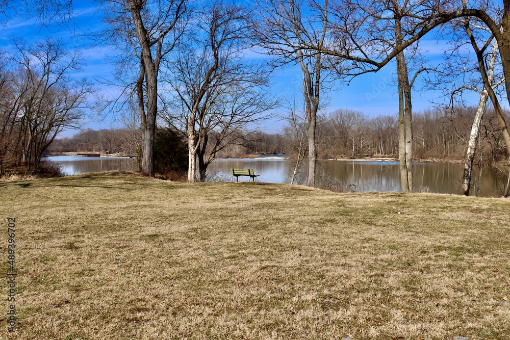 The empty bench on the riverbank on a sunny day. The empty bench on the riverbank on a sunny day.