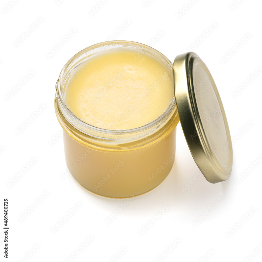Open glass jar with yellow ghee close up isolatede on white background Open glass jar with yellow ghee close up isolatede on white background