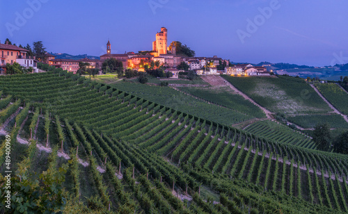 Serralunga d'Alba village illuminated in the evening. Langhe region of Piedmont, Cuneo, northern Italy.	 photo