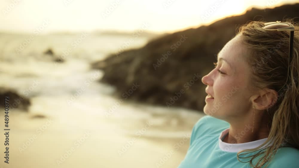 Drink funny woman leaning on a rock reef with seashells enjoying the warm golden sunset. Woman in blue swimsuit and sunglasses. Concept rest tropical resort traveling tourism happy summer holidays Drink funny woman leaning on a rock reef with seashells enjoying the warm golden sunset. Woman in blue swimsuit and sunglasses. Concept rest tropical resort traveling tourism happy summer holidays
