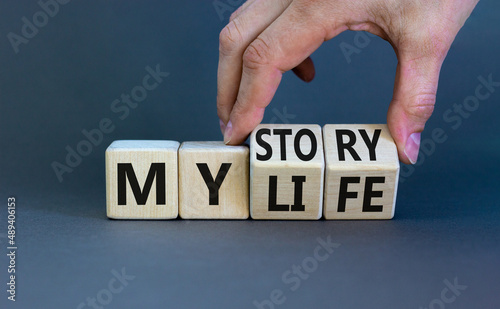 Story of my life symbol. Businessman turns wooden cubes and changes concept words My story to My life. Beautiful grey table grey background. Business story of my life concept. Copy space.