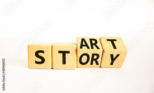 Start your story symbol. Turned wooden cubes and changed the concept word Start to Story. Beautiful white table white background, copy space. Business start your story concept.
