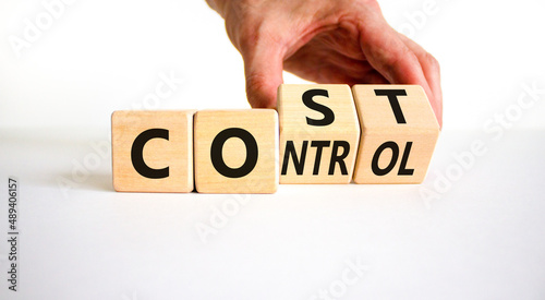 Cost control symbol. Businessman turns wooden cubes and changes the concept word Cost to Control. Beautiful white table white background, copy space. Business cost control concept. photo