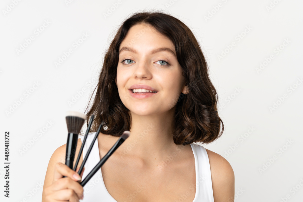Teenager Ukrainian girl isolated on white background holding makeup brush Teenager Ukrainian girl isolated on white background holding makeup brush