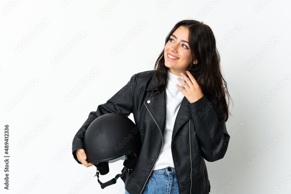 Woman holding a motorcycle helmet isolated on white background looking up while smiling Woman holding a motorcycle helmet isolated on white background looking up while smiling