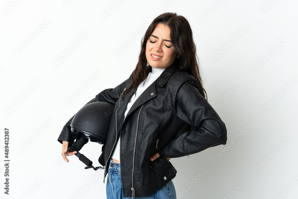Woman holding a motorcycle helmet isolated on white background suffering from backache for having made an effort Woman holding a motorcycle helmet isolated on white background suffering from backache for having made an effort