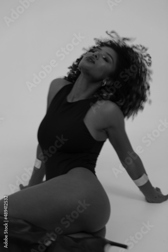 Portrait of black young woman with perfect body posing on white background.