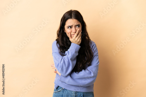 Young caucasian woman over isolated background having doubts and with confuse face expression