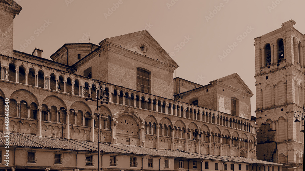 Ferrara, Italy. Ancient Loggia dei Merciai and cathedral bell tower. Sepia photo.