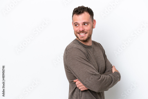 Young Brazilian man isolated on white background looking to the side and smiling © luismolinero