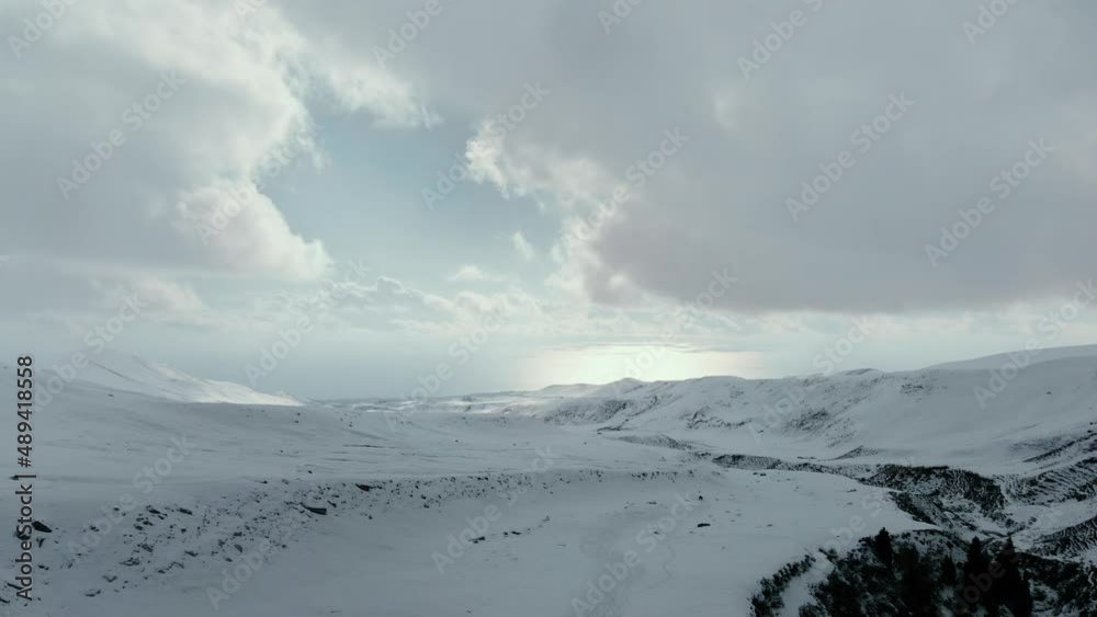 Aerial view of mountains covered with snow and lake in background