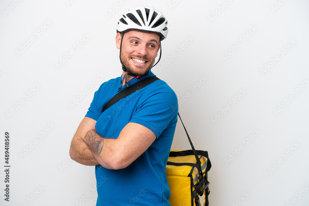 Young brazilian man with thermal backpack isolated on white background with arms crossed and happy Young brazilian man with thermal backpack isolated on white background with arms crossed and happy