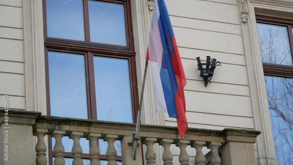 Russian national flag fluttering on a pole on the wall of Krakow Consulate General of Russia or embassy in Kraków, Poland. Russian national flag fluttering on a pole on the wall of Krakow Consulate General of Russia or embassy in Kraków, Poland.