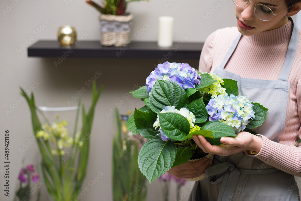Young woman professional florist working with flowers in her flower shop. Young woman professional florist working with flowers in her flower shop.
