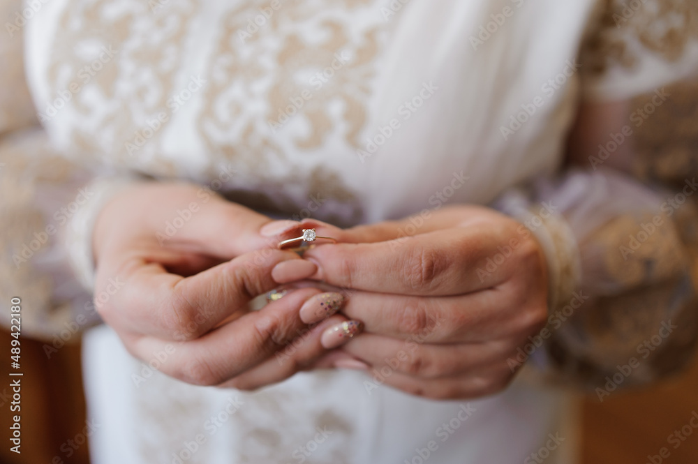 A pair of wedding gold rings in the hands of the bride. Wedding rings on a female hand