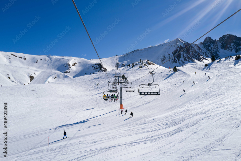 People riding ski lift in ski resort - obrazy, fototapety, plakaty 