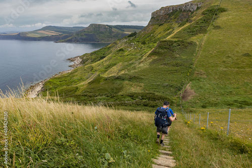 Hikers walk down a steep set of steps on the South West Coast Path in Dorset as they approach Emmetts Hill